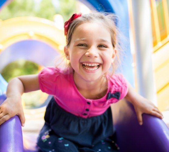 Young girl grinning on outdoor playground