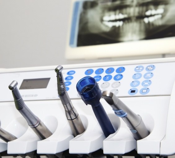 Dental instruments with x rays of teeth in background