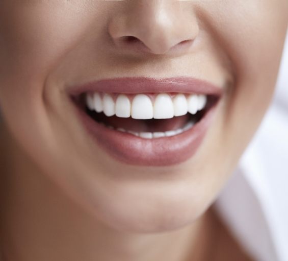 Close up of person smiling with straight white teeth