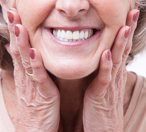 a woman smiling holding her cheeks