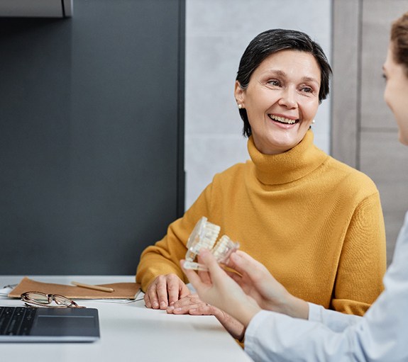 a woman speaking with her dentist about dentures