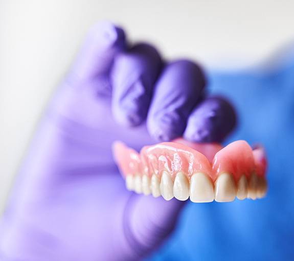 a hand holding up a denture